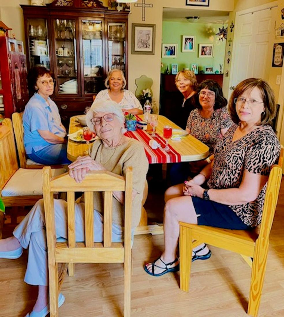 Sylvia and five other writer’s group members sitting around a table